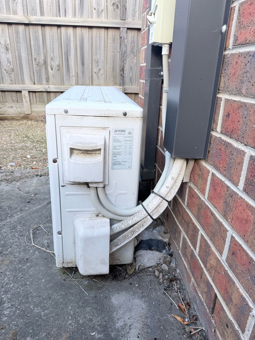 Air conditioner condensate pipe of the wrong type, discharging against the house, found during a defect investigation inspection in Truganina