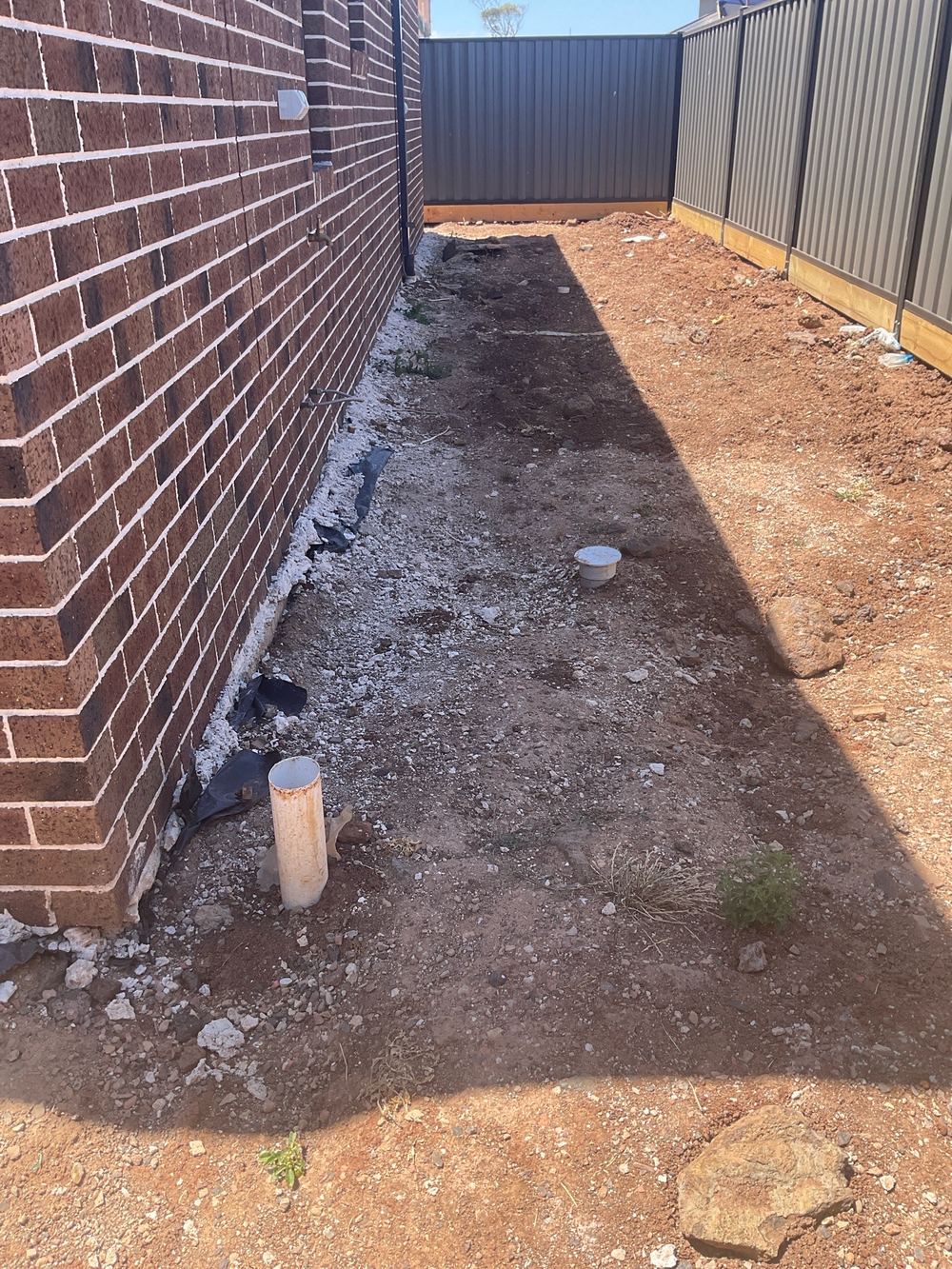 Ground still not graded away from the slab at handover, found during a pre-handover inspection in Truganina