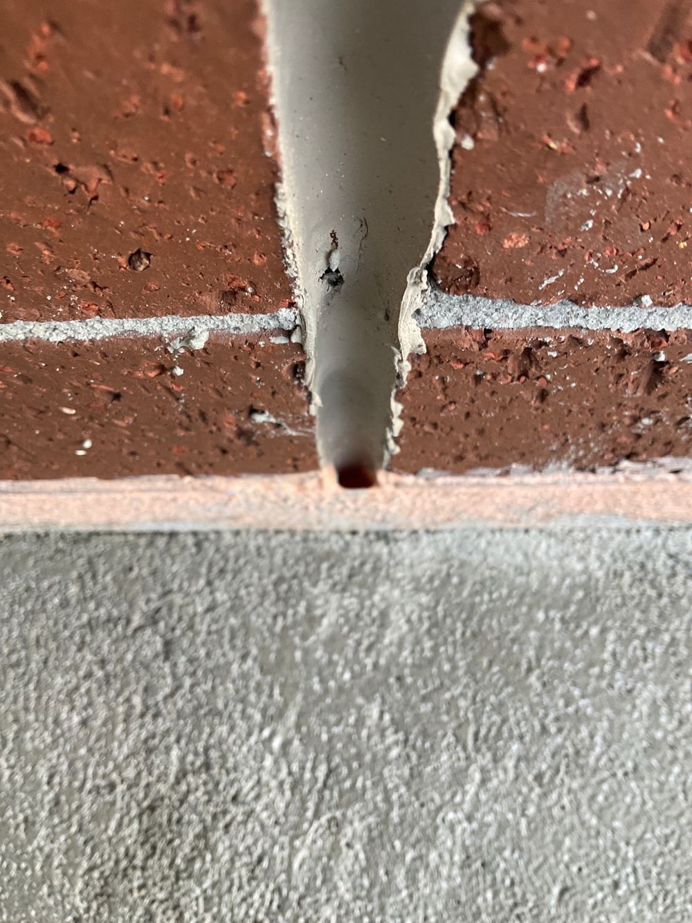 Articulation joint left unsealed, letting water in behind the joint band, found during a waterproofing inspection in Truganina